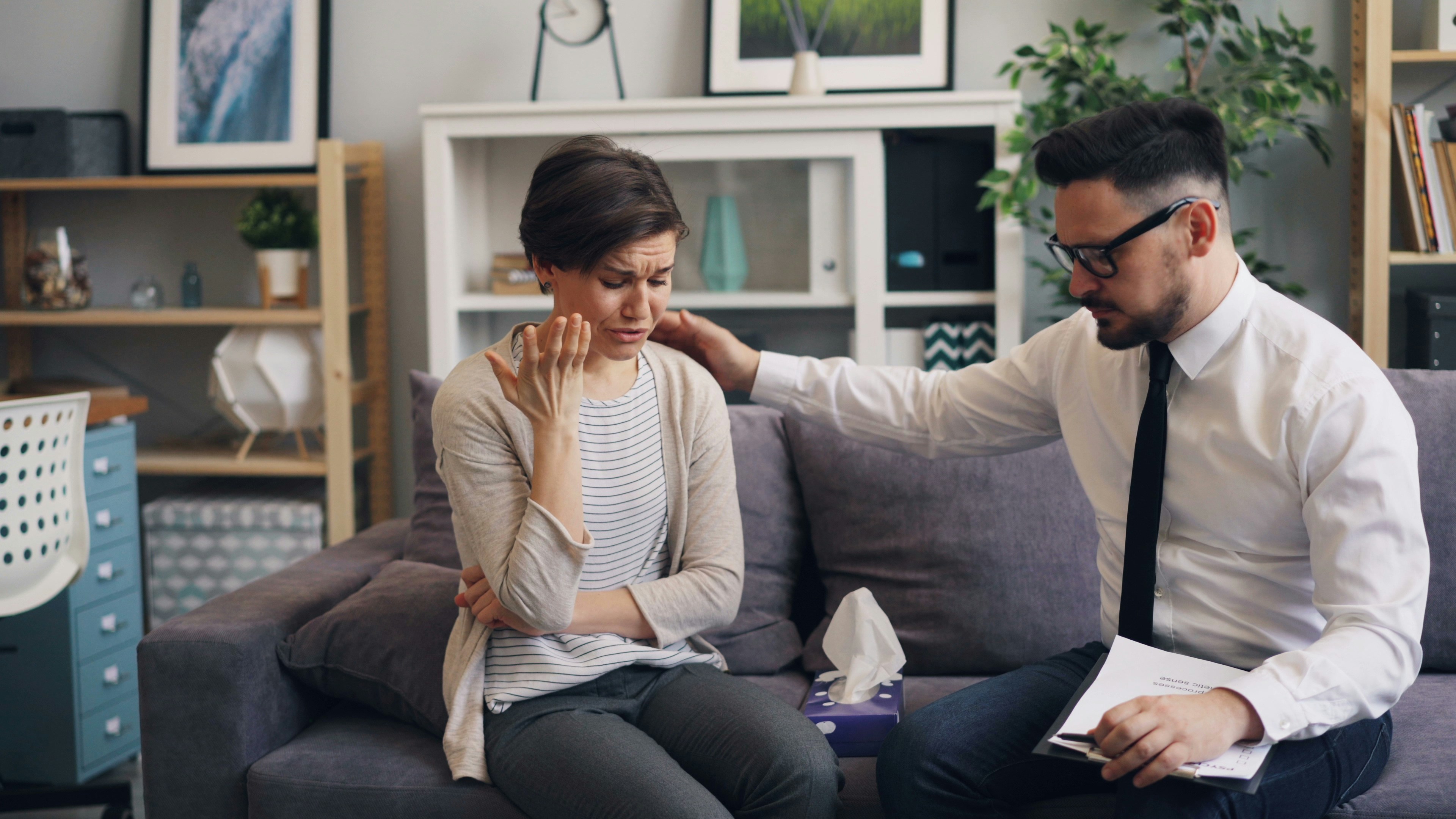 A couple sitting close together during an emotional moment, showing the deep connection fostered in therapy