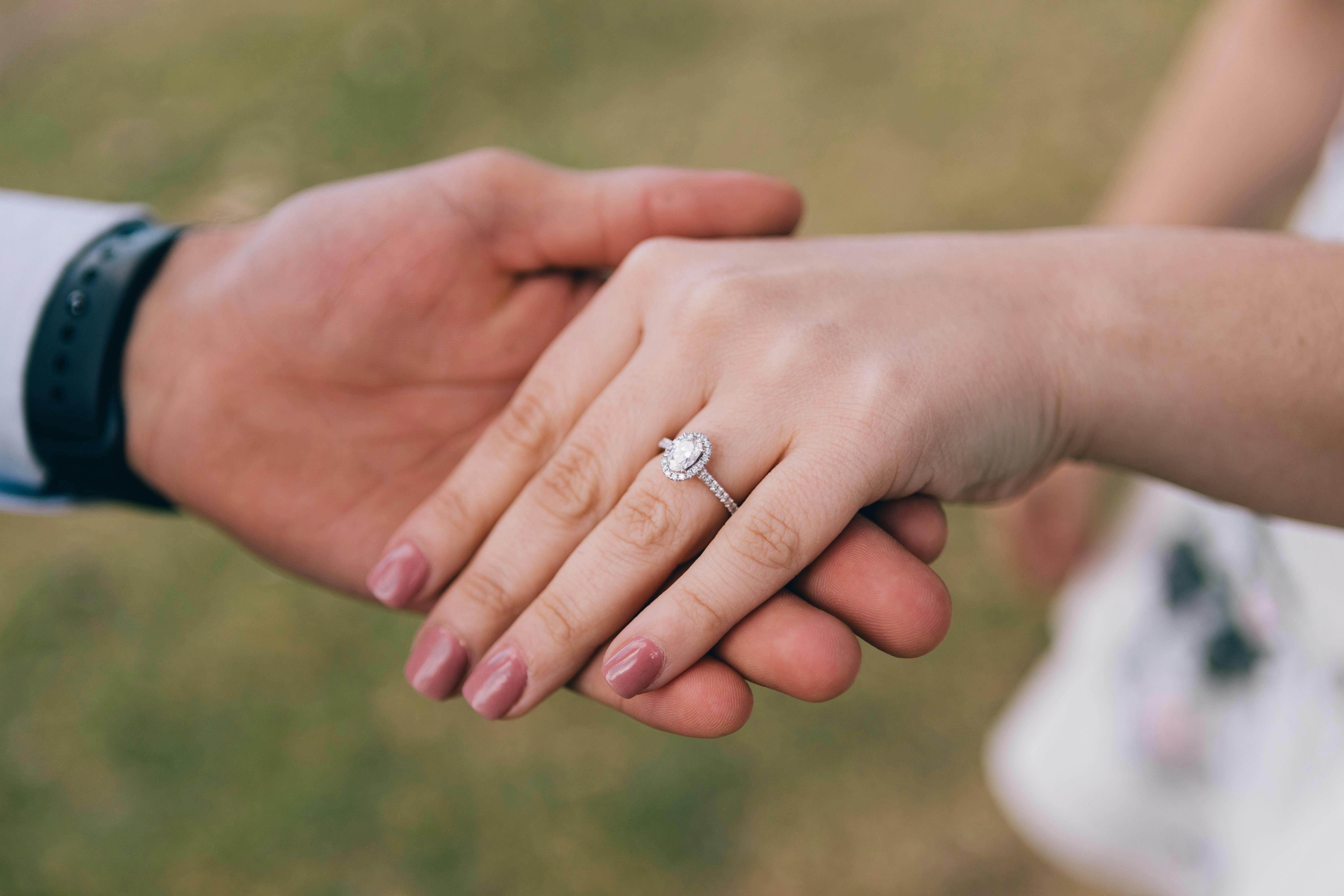 couple's hands with an engagement ring